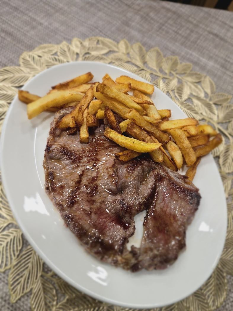 Entrecot de ternera a la plancha, servido con patatas fritas.